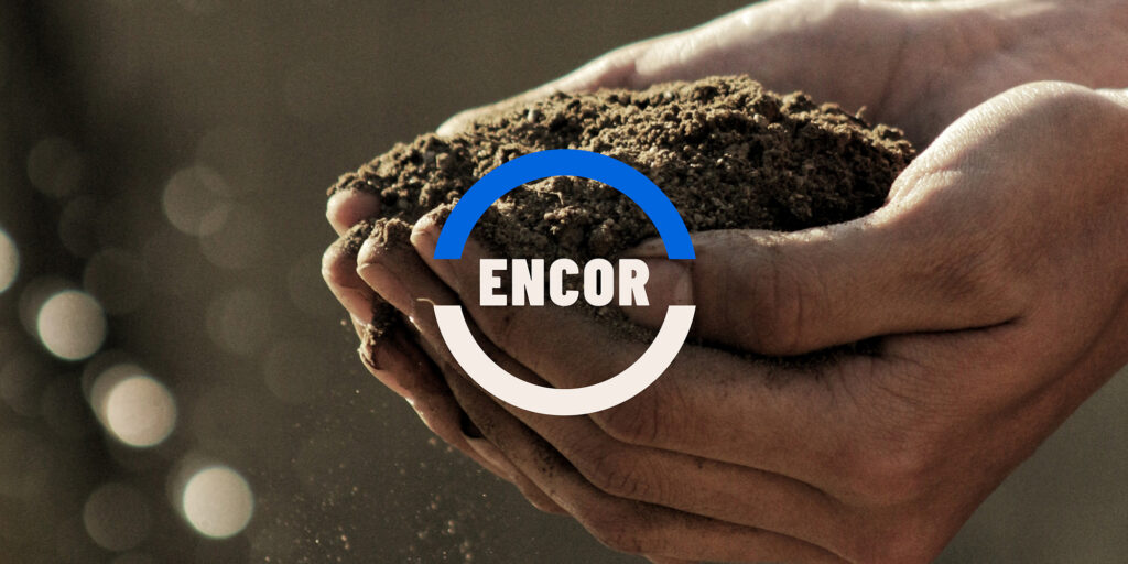 Handen die aarde vasthouden, met het Encor logo er overheen.