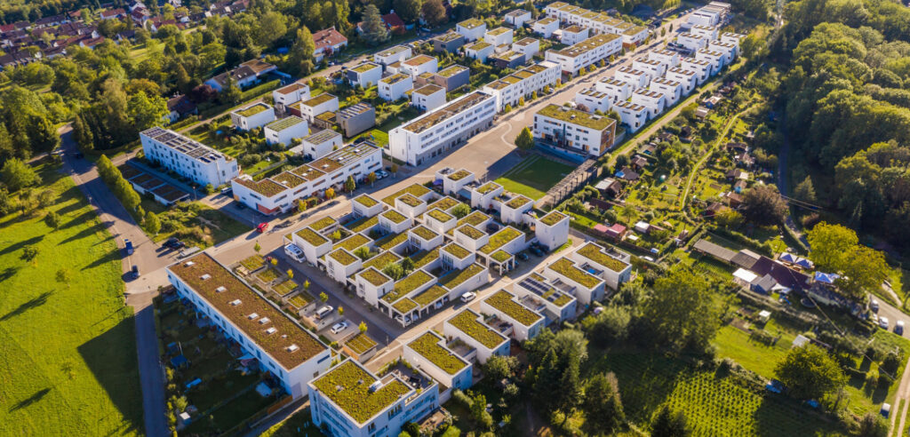 Een droneshot van een woonwijk in het groen.
